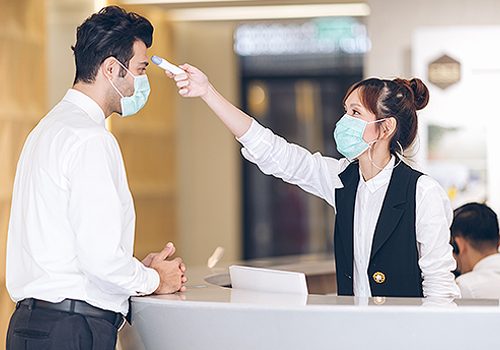Woman Checking Man's Temperature In a Hospital Lobby