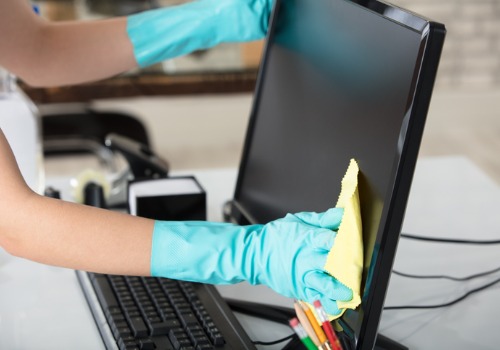 Woman wiping dust off a monitor during Office Cleaning in Washington IL
