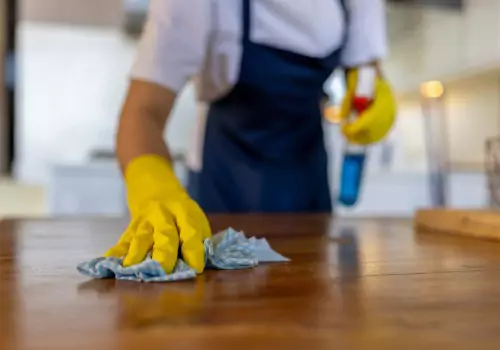 Spraying and wiping down countertop surfaces during vacant residential cleaning in Peoria IL.