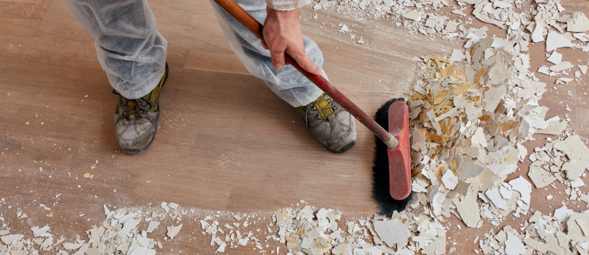 A team member of Pro Kleen, a post-construction cleanup team, sweeps the floor after a renovation