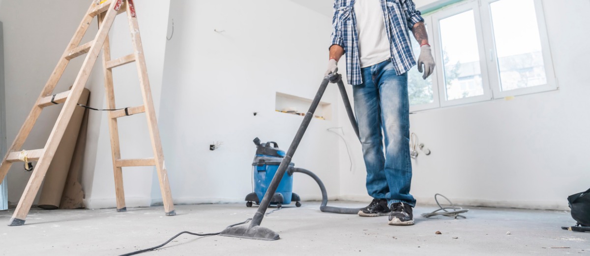 A team member of Pro Kleen, a post-construction cleanup team, vacuums the floor
