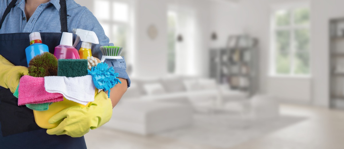 A professional cleaner from Pro Kleen, which offers vacant residential cleaning, stands holding a bucket of cleaning supplies.