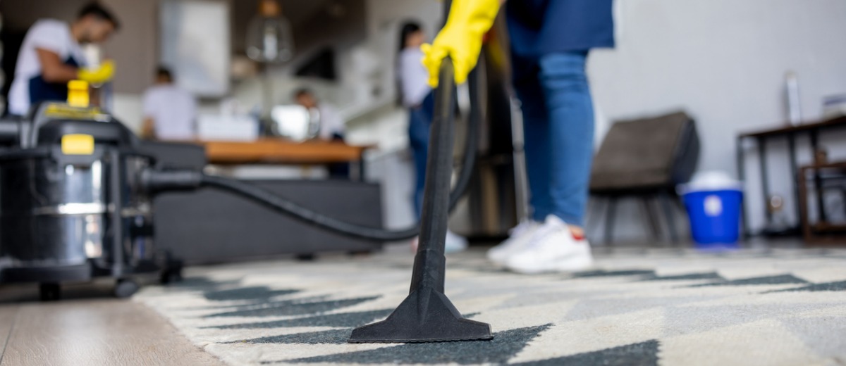 A professional cleaner from Pro Kleen, which provides cleaning & disinfection services, deep cleans a carpet.