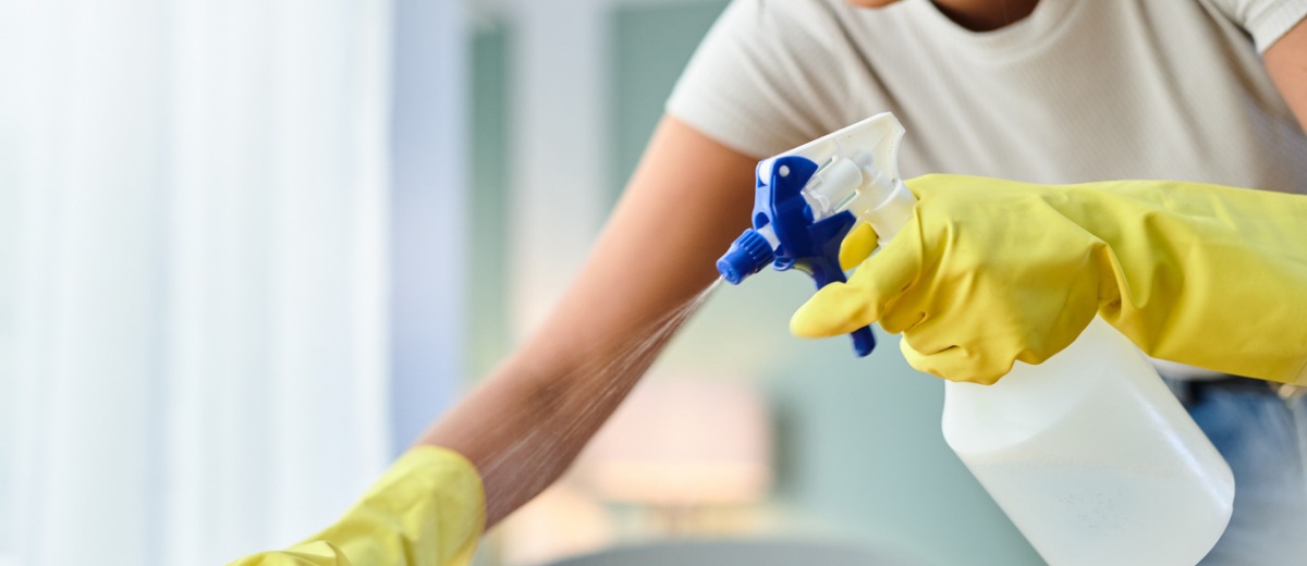 A female team member from Pro Kleen, which offers Champaign commercial cleaning services, dusts a table in an office
