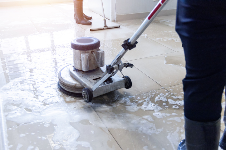 Office Cleaning Services Peoria IL, Janitor use floor scrubber machine on the floor hallway office building or walkway after school and classroom work job with sun light background. Wet floor or cleaning service house maid concept